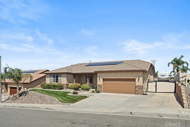 1472 Coyote Ln, Calimesa, CA 92320 - view of front of property featuring stone siding, stucco siding, a garage, a gate, and roof mounted solar panels