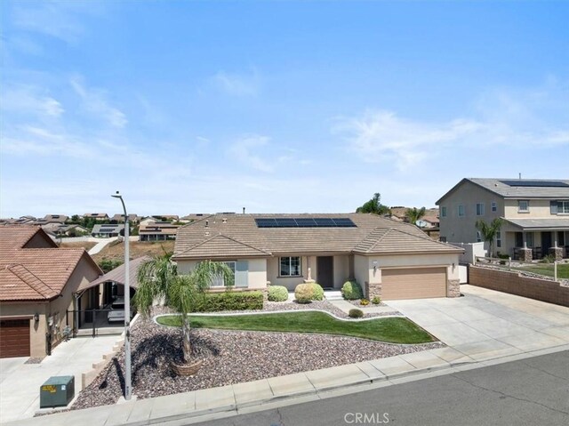 1472 Coyote Ln, Calimesa, CA 92320 - single story home with stucco siding, an attached garage, concrete driveway, roof mounted solar panels, and a residential view