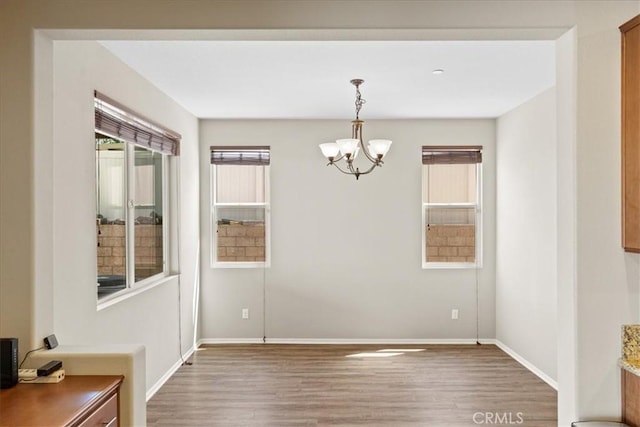 1472 Coyote Ln, Calimesa, CA 92320 - unfurnished dining area with a chandelier, wood finished floors, and baseboards