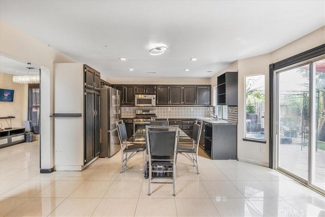 507 Coudures Way, Perris, CA 92571 - kitchen featuring stainless steel appliances, dark brown cabinets, tasteful backsplash, and light tile patterned floors