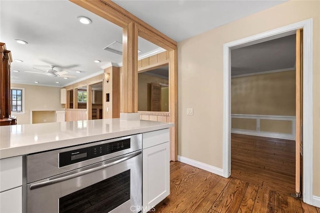 15454 Sutton St, Sherman Oaks, CA 91403 - kitchen featuring ornamental molding, oven, light countertops, ceiling fan, and white cabinets