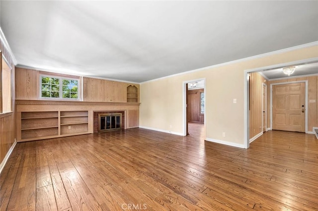 15454 Sutton St, Sherman Oaks, CA 91403 - unfurnished living room featuring hardwood / wood-style floors, crown molding, built in features, a glass covered fireplace, and baseboards