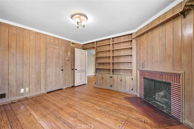 15454 Sutton St, Sherman Oaks, CA 91403 - unfurnished living room featuring a brick fireplace, wooden walls, ornamental molding, hardwood / wood-style floors, and built in features