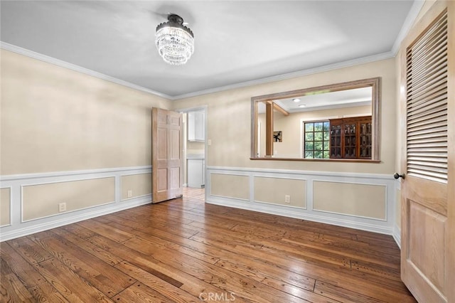 15454 Sutton St, Sherman Oaks, CA 91403 - unfurnished dining area featuring a chandelier, hardwood / wood-style flooring, ornamental molding, a wainscoted wall, and a decorative wall
