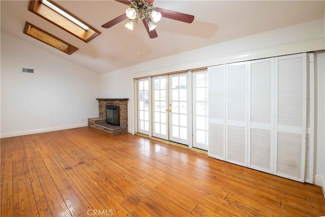 10425 Hillview Ave, Chatsworth, CA 91311 - unfurnished living room featuring vaulted ceiling, a skylight, ceiling fan, wood-type flooring, and a fireplace