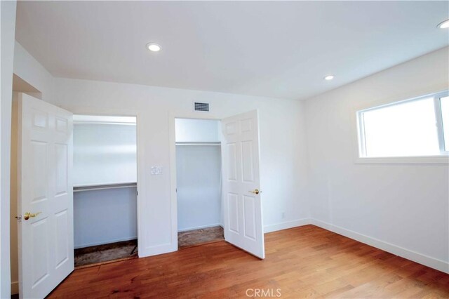 10425 Hillview Ave, Chatsworth, CA 91311 - unfurnished bedroom with wood finished floors, two closets, and recessed lighting