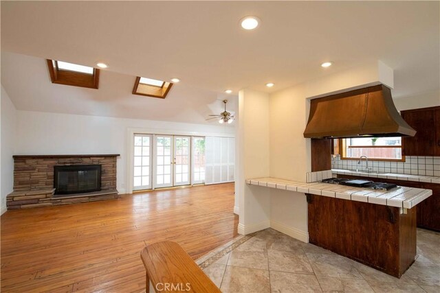 10425 Hillview Ave, Chatsworth, CA 91311 - kitchen featuring tile counters, backsplash, open floor plan, a sink, and baseboards