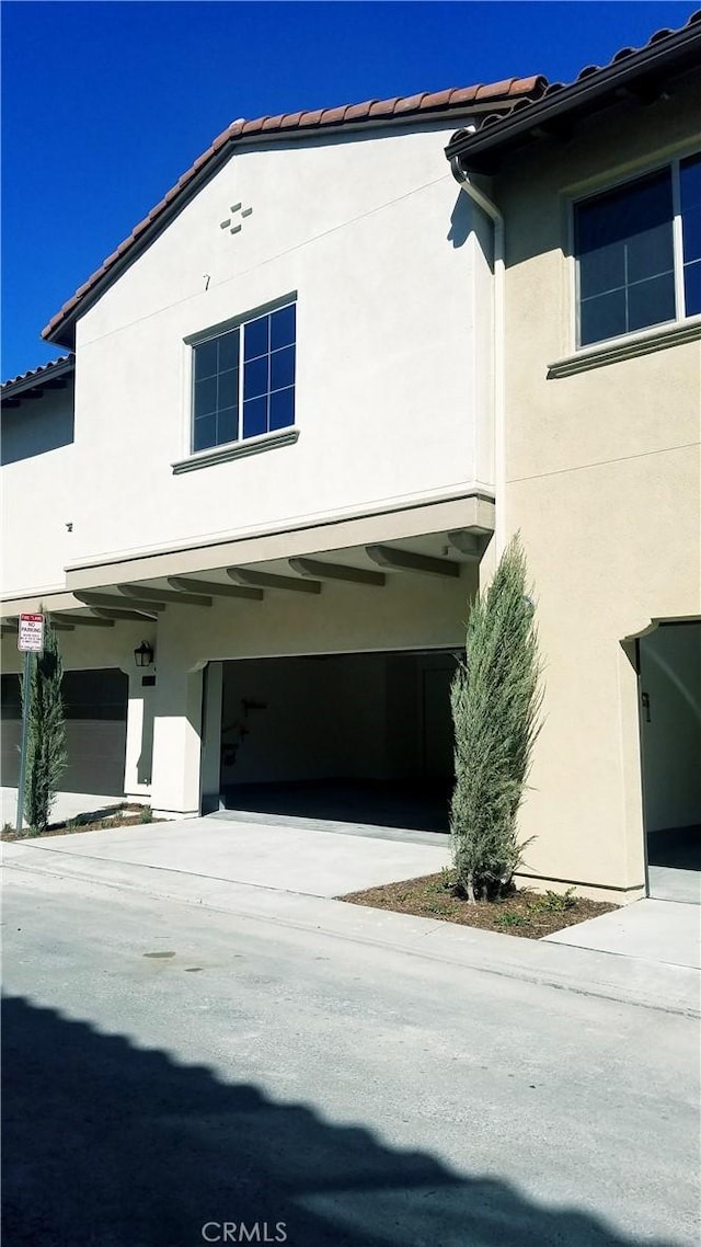 163 Lantana Dr, Stanton, CA 90680 - view of home's exterior featuring stucco siding, a tiled roof, a garage, and driveway