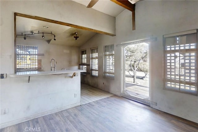60220 Chalet Dr, Mountain Center, CA 92561 - kitchen featuring wood finished floors, beam ceiling, a ceiling fan, a peninsula, and a breakfast bar area