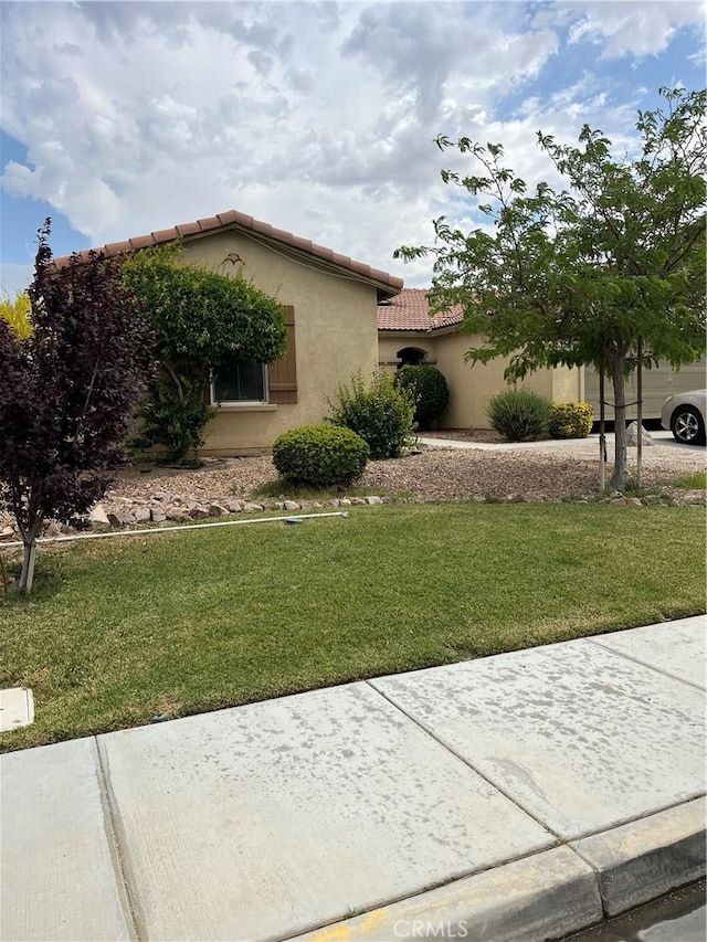 6875 Adainville Dr, Palmdale, CA 93552 - view of front of property with a tile roof, stucco siding, and a front lawn