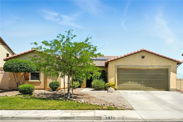 6875 Adainville Dr, Palmdale, CA 93552 - mediterranean / spanish-style home featuring roof mounted solar panels, stucco siding, an attached garage, and concrete driveway