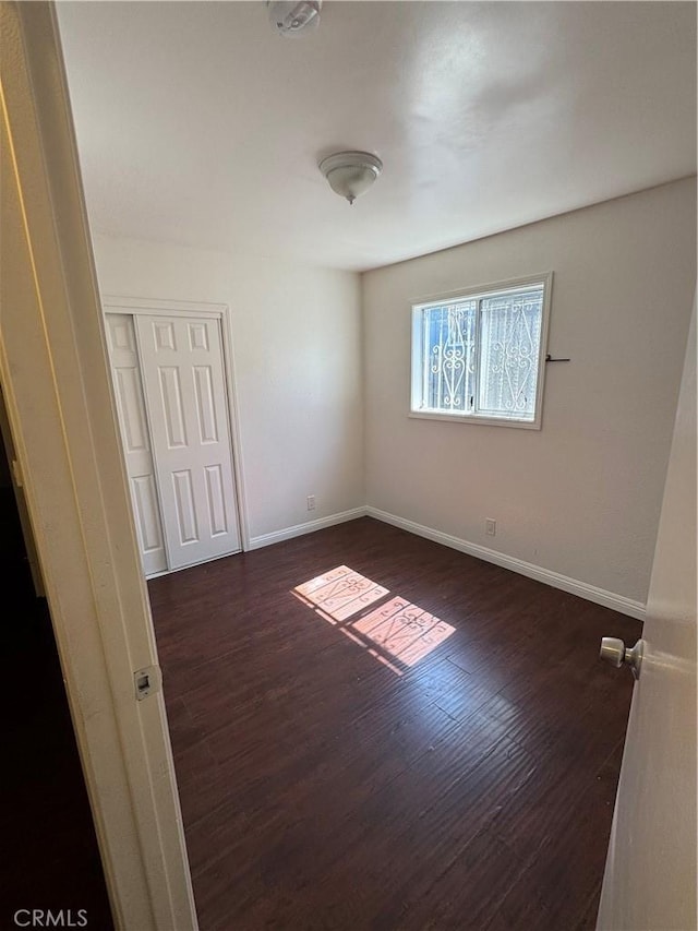 2622 E 129th St, Compton, CA 90222 - empty room featuring dark wood-style floors and baseboards