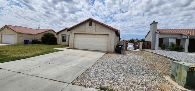 15009 Hopland St, Victorville, CA 92394 - view of front of property with an attached garage, concrete driveway, a tile roof, stucco siding, and a gate