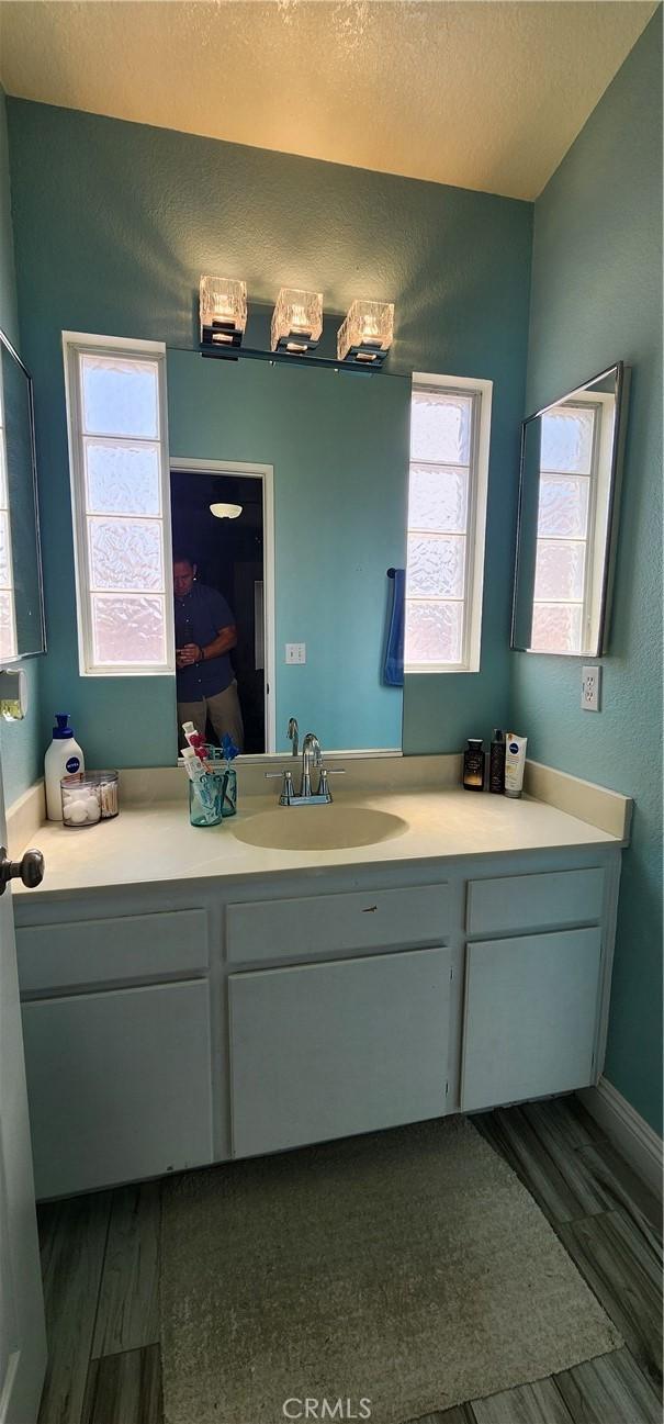 15009 Hopland St, Victorville, CA 92394 - bathroom featuring vanity, wood finished floors, and baseboards