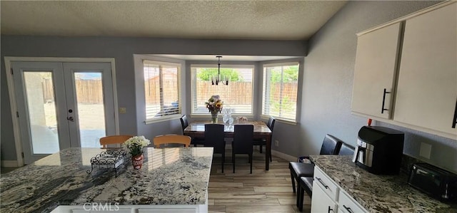 15009 Hopland St, Victorville, CA 92394 - dining room with light wood-type flooring, a textured ceiling, a chandelier, french doors, and baseboards