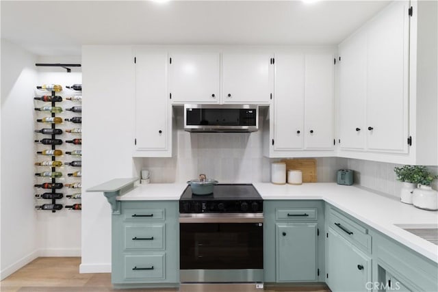 3695 Linden Ave Unit 10C, Long Beach, CA 90807 - kitchen with electric range oven, stainless steel microwave, light countertops, and white cabinetry