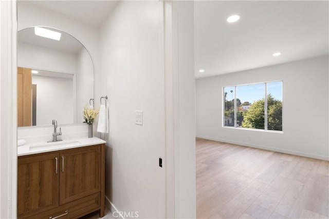3695 Linden Ave Unit 10C, Long Beach, CA 90807 - bathroom with vanity, wood finished floors, recessed lighting, and baseboards