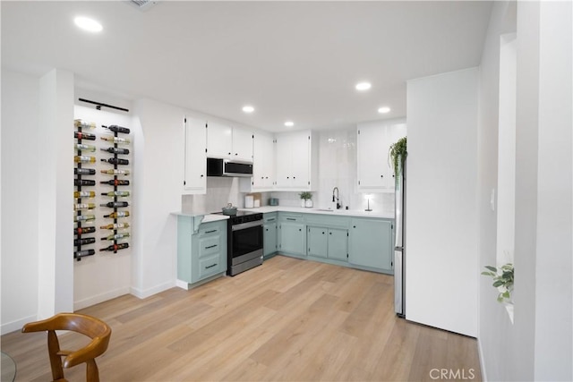 3695 Linden Ave Unit 10C, Long Beach, CA 90807 - kitchen with stainless steel appliances, recessed lighting, light countertops, blue cabinets, and light wood finished floors