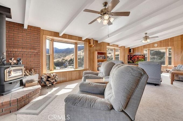 28560 Cruthers Creek Rd, Pearblossom, CA 93553 - carpeted living area with a wood stove, a mountain view, wood walls, and a ceiling fan