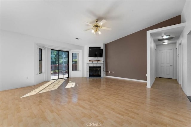 22022 Grove Cir, Red Bluff, CA 96080 - unfurnished living room featuring light wood finished floors, a tiled fireplace, ceiling fan, lofted ceiling, and baseboards