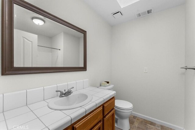 22022 Grove Cir, Red Bluff, CA 96080 - bathroom featuring vanity, toilet, baseboards, and a shower