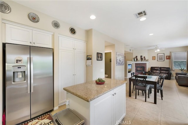 13 Arborside Way, Mission Viejo, CA 92692 - kitchen with stainless steel fridge with ice dispenser, a brick fireplace, a center island, open floor plan, and white cabinetry