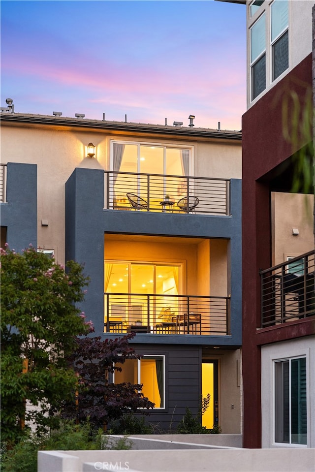 150 Abacus, Irvine, CA 92618 - back of house at dusk featuring a balcony and stucco siding
