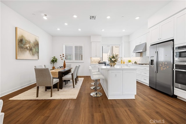 150 Abacus, Irvine, CA 92618 - kitchen with stainless steel appliances, under cabinet range hood, a kitchen island, white cabinetry, and recessed lighting