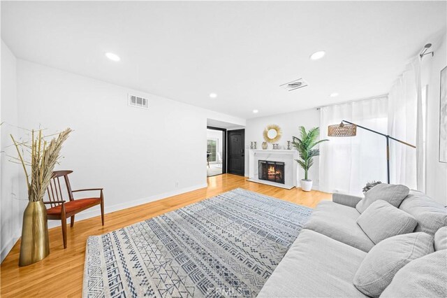 934 W Bonnie Brae Ct, Ontario, CA 91762 - living area featuring light wood-type flooring, recessed lighting, a lit fireplace, and baseboards