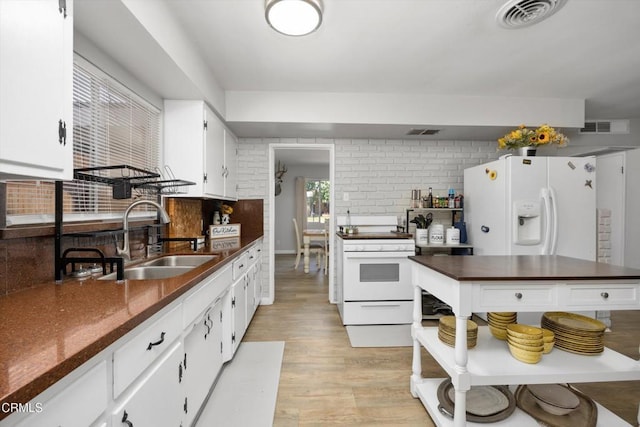 10217 Enger St, Bakersfield, CA 93312 - kitchen featuring white appliances, a sink, dark countertops, light wood-type flooring, and white cabinetry