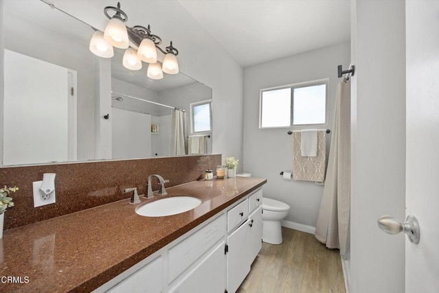 10217 Enger St, Bakersfield, CA 93312 - bathroom with vanity, toilet, baseboards, wood finished floors, and curtained shower
