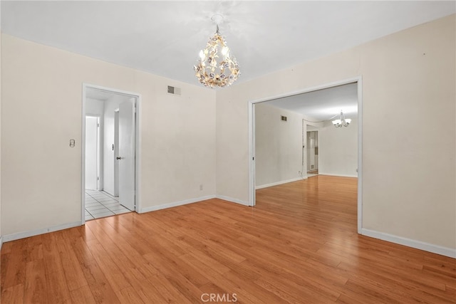 10120 Andasol Ave, Northridge, CA 91325 - spare room with a chandelier, light wood finished floors, and baseboards