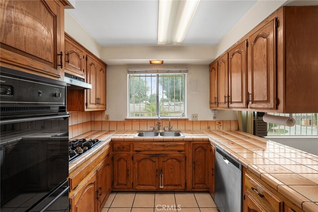 10120 Andasol Ave, Northridge, CA 91325 - kitchen with black appliances, a sink, tile counters, and brown cabinetry