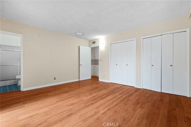 10120 Andasol Ave, Northridge, CA 91325 - unfurnished bedroom with light wood-type flooring, multiple closets, a textured ceiling, baseboards, and ensuite bath