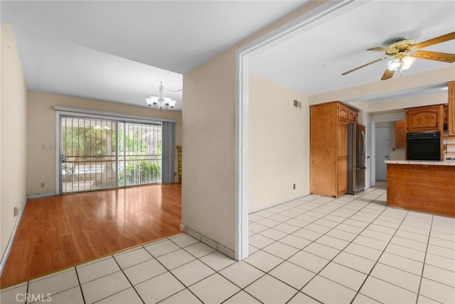 10120 Andasol Ave, Northridge, CA 91325 - kitchen featuring oven, freestanding refrigerator, brown cabinets, a ceiling fan, and a chandelier