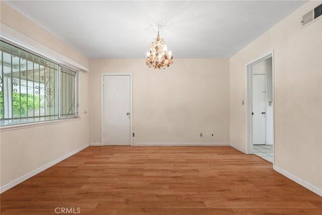 10120 Andasol Ave, Northridge, CA 91325 - spare room with a chandelier, light wood finished floors, and baseboards