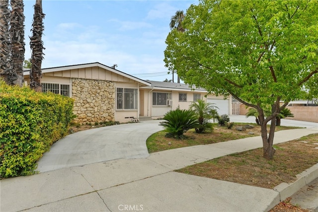 10120 Andasol Ave, Northridge, CA 91325 - ranch-style home featuring stone siding, concrete driveway, and an attached garage