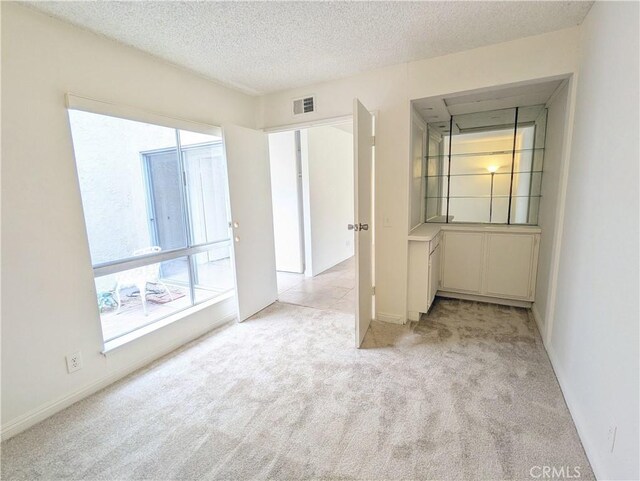 2811 Lancewood Ct, Fullerton, CA 92835 - spare room featuring light carpet, a textured ceiling, and baseboards