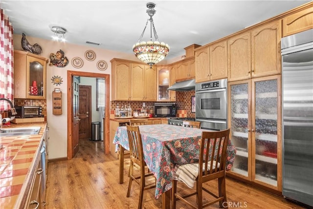 4611 S Gramercy Pl, Los Angeles, CA 90062 - kitchen featuring tile counters, a sink, appliances with stainless steel finishes, and tasteful backsplash