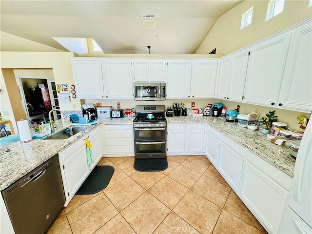 8925 Fallbrook Ct, Hesperia, CA 92344 - kitchen with appliances with stainless steel finishes, vaulted ceiling, light tile patterned flooring, white cabinets, and light stone countertops