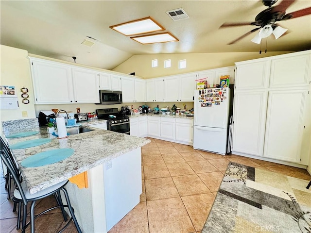 8925 Fallbrook Ct, Hesperia, CA 92344 - kitchen with appliances with stainless steel finishes, lofted ceiling, a peninsula, a sink, and white cabinets