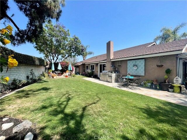 18839 Watson Ave, Cerritos, CA 90703 - view of green lawn with a patio and an outdoor kitchen