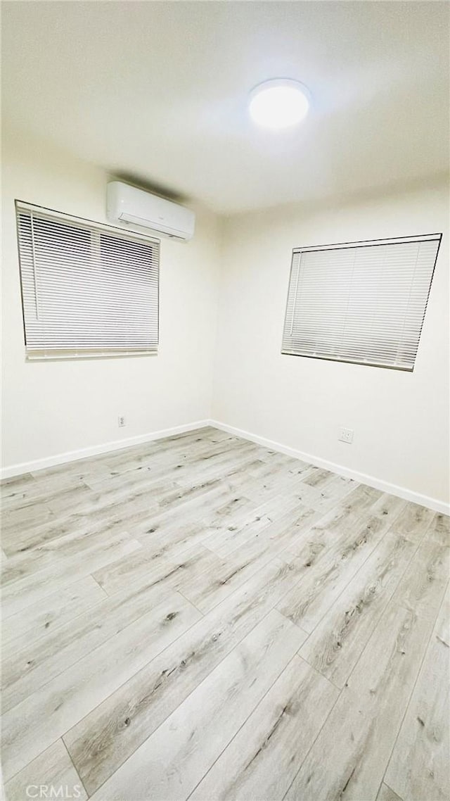 14940 Beckner St, La Puente, CA 91744 - empty room featuring wood finished floors, a wall mounted air conditioner, and baseboards