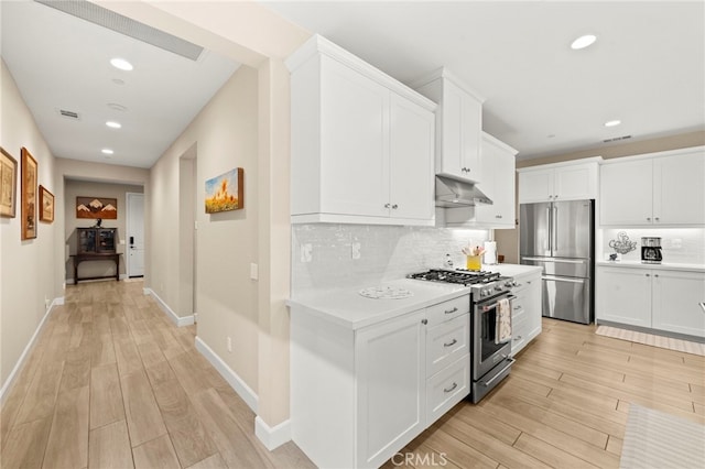 34452 Turquoise Ln, Murrieta, CA 92563 - kitchen with stainless steel appliances, under cabinet range hood, light countertops, light wood-style flooring, and recessed lighting