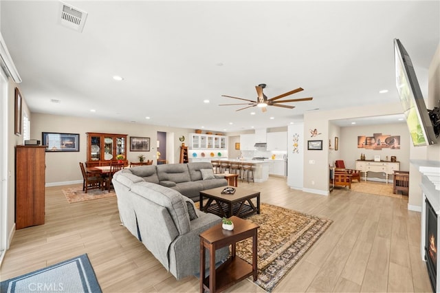 34452 Turquoise Ln, Murrieta, CA 92563 - living area featuring a warm lit fireplace, light wood-type flooring, ceiling fan, baseboards, and recessed lighting