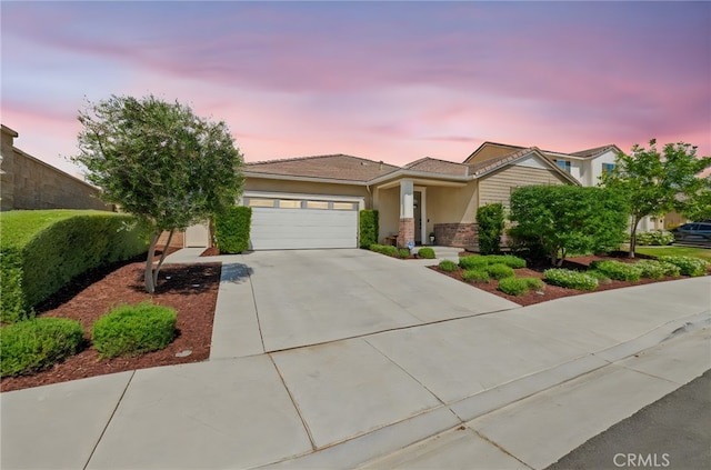 34452 Turquoise Ln, Murrieta, CA 92563 - view of front of home featuring a garage, concrete driveway, stucco siding, and stone siding
