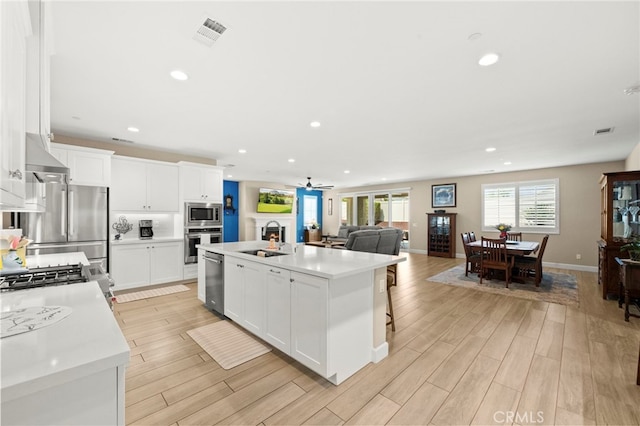 34452 Turquoise Ln, Murrieta, CA 92563 - kitchen with a sink, appliances with stainless steel finishes, a center island with sink, recessed lighting, and light countertops