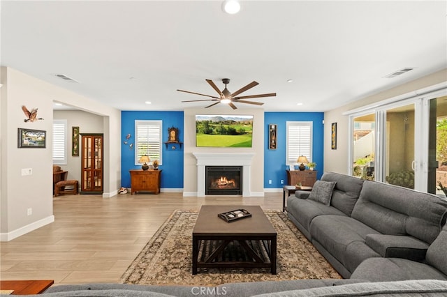34452 Turquoise Ln, Murrieta, CA 92563 - living area featuring a warm lit fireplace, light wood finished floors, ceiling fan, baseboards, and recessed lighting