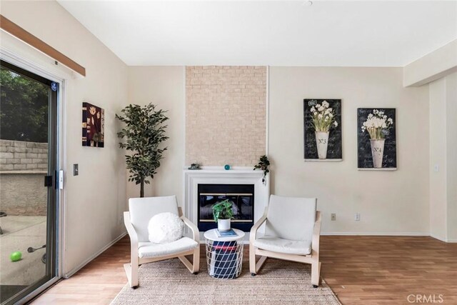 13421 Hubbard St Unit 125, Sylmar, CA 91342 - living area featuring wood finished floors, a fireplace, and baseboards