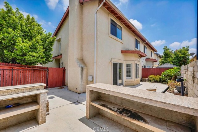 13421 Hubbard St Unit 125, Sylmar, CA 91342 - rear view of house with stucco siding, a patio, and a fenced backyard